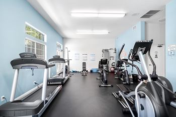 A spacious gym with treadmills, elliptical machines, and other exercise equipment.